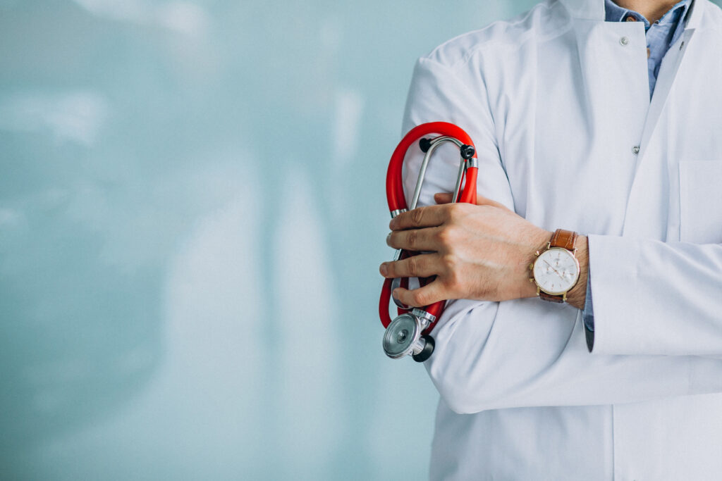 Young handsome physician in a medical robe with stethoscope - Evolve Your Success