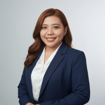 Professional portrait of a smiling woman in a navy blazer and white blouse, facing the camera for a business profile.